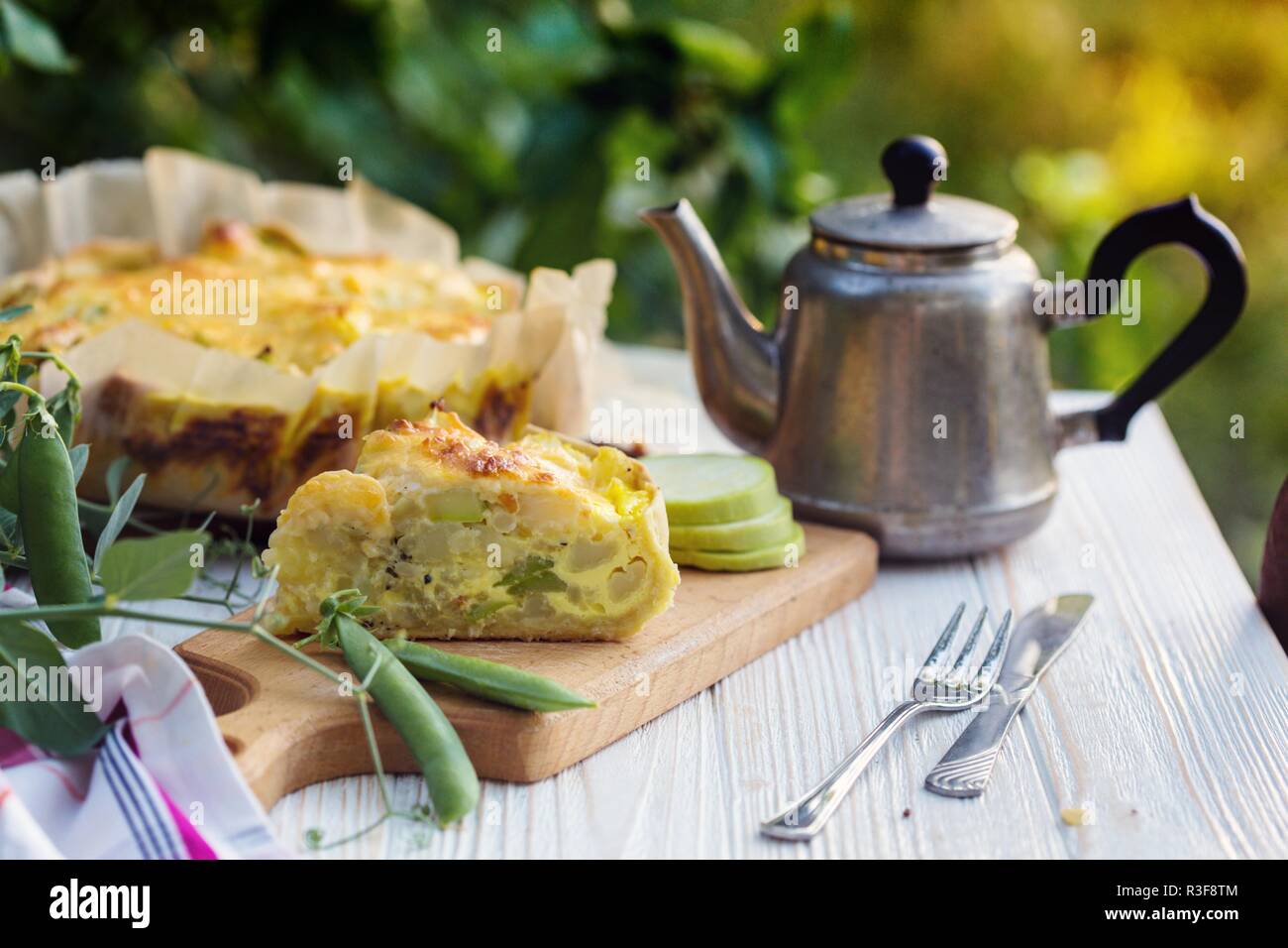 La tarte. Tartes aux légumes - le brocoli, courgettes et fromage dans le jardin au coucher du soleil la lumière Banque D'Images