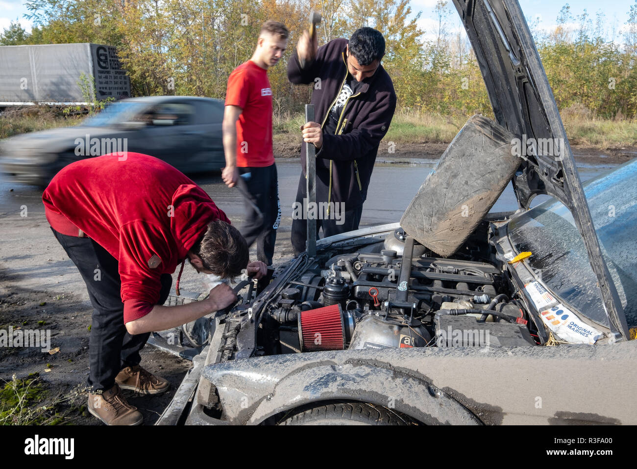 Varsovie / Pologne - 21 octobre 2018 : 3 hommes la réparation de voiture endommagée au cours de la dérive en événement amateur Ursus, usine de tracteurs abandonnés en banlieue de Varsovie. Banque D'Images