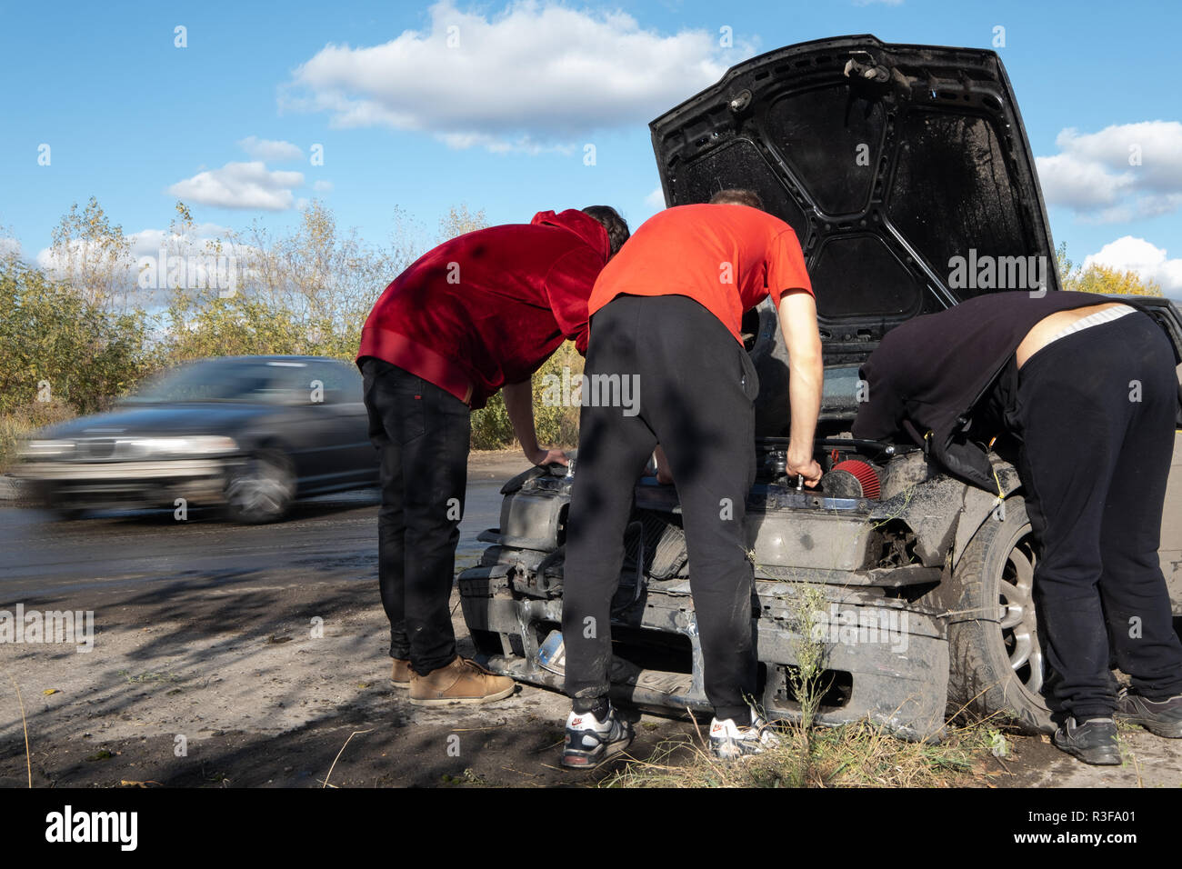 Varsovie / Pologne - 21 octobre 2018 : 3 hommes la réparation de voiture endommagée au cours de la dérive en événement amateur Ursus, usine de tracteurs abandonnés en banlieue de Varsovie. Banque D'Images