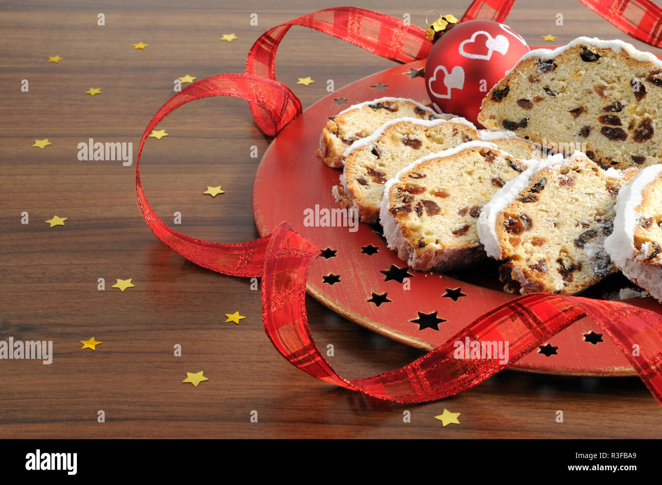 Stollen de Noël gâteau de fruit avec du sucre en poudre sur la table avec un ruban rouge. gâteau de Noël traditionnel allemand. Banque D'Images