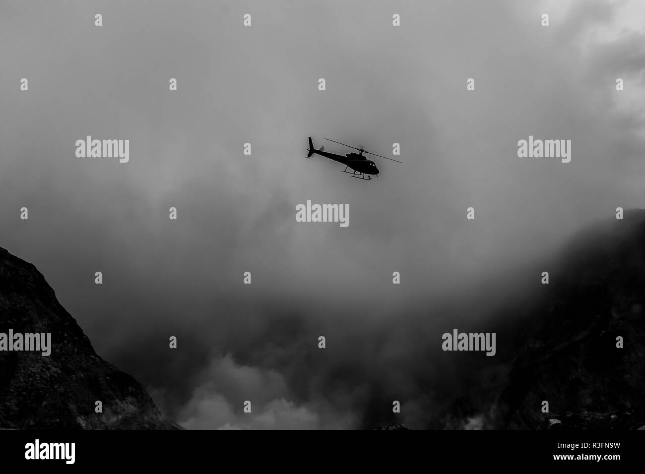 Un hélicoptère volant à travers la fumée sur White Island, New Zealand Banque D'Images
