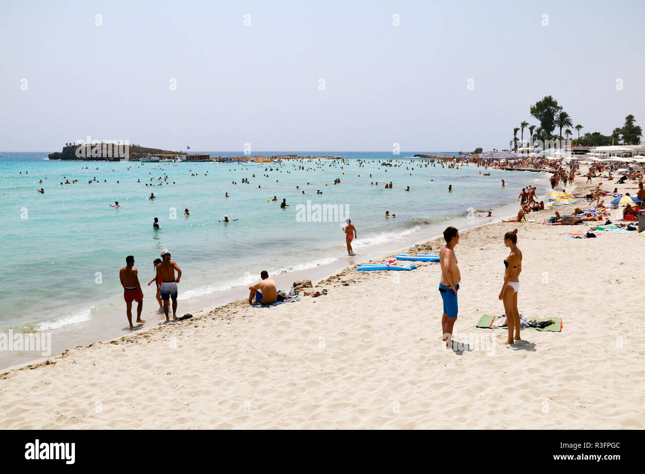 Les vacanciers se détendre au soleil sur la plage de Nissi, Ayia Napa, Chypre Banque D'Images