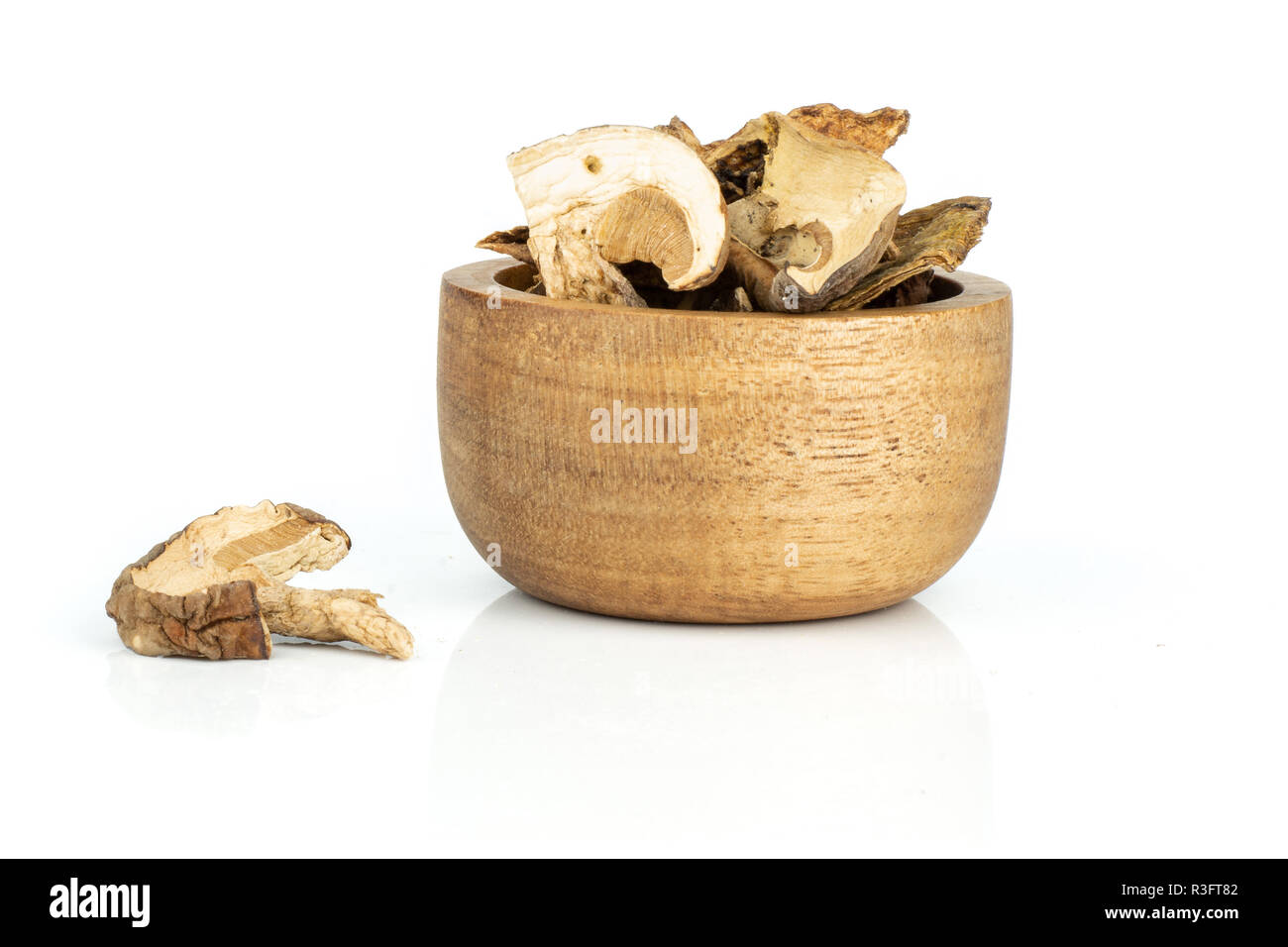 Beaucoup de tranches de champignons bruns secs boletus edulis variété avec bol en bois isolé sur fond blanc Banque D'Images