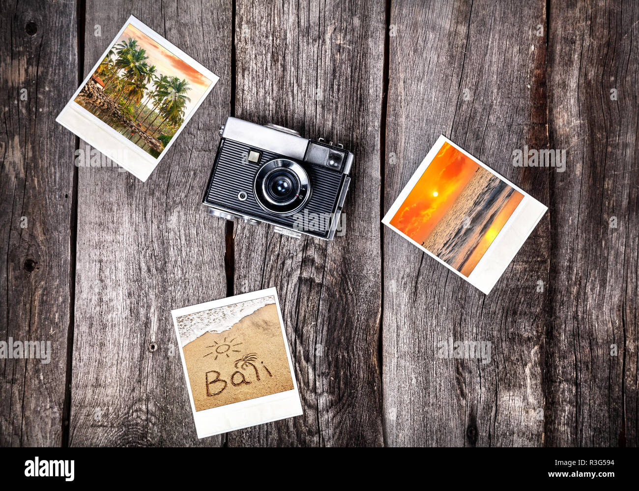 Vieux film Polaroid appareil photo et photos avec plages tropicales de Bali sur le fond en bois Banque D'Images