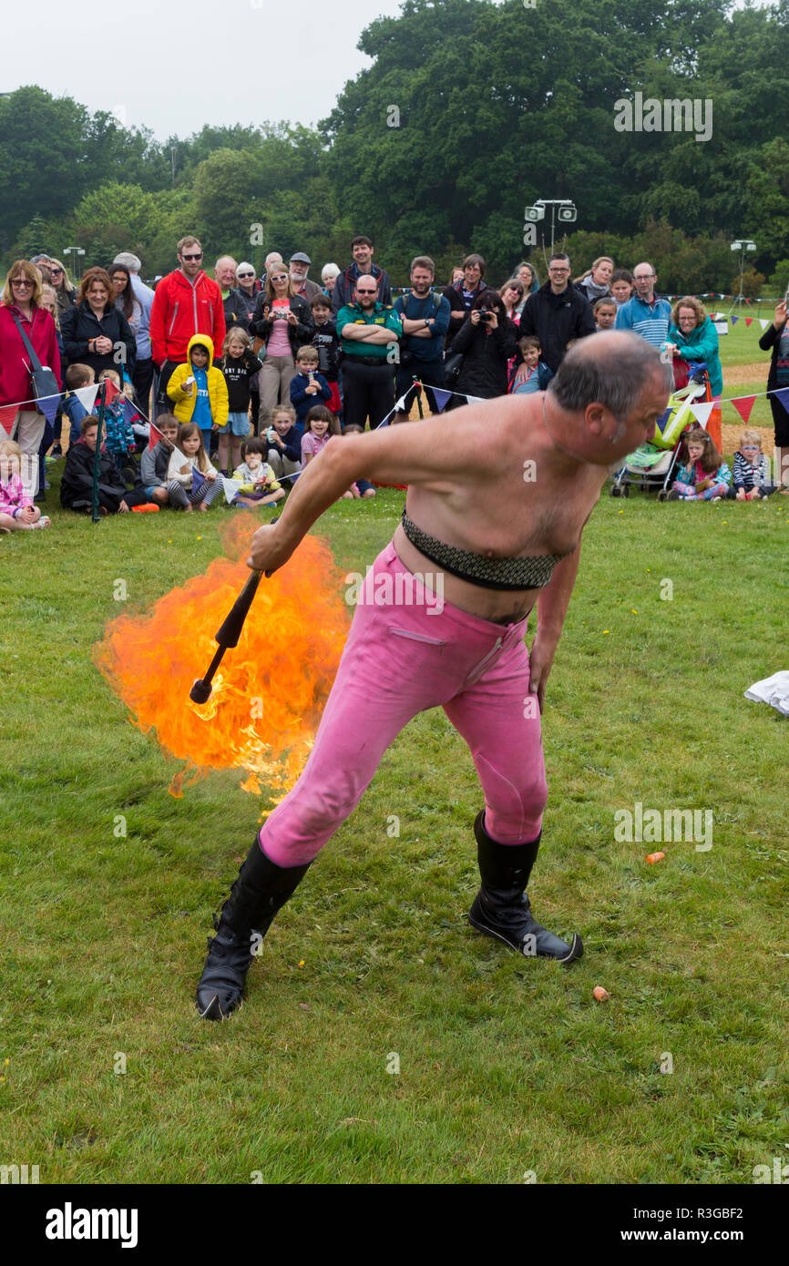 Homme / interprète de mettre le feu à son pet lors d'un affichage humoristique de la jonglerie avec le feu et l'incendie de manger en face d'un auditoire. England UK. (98) Banque D'Images