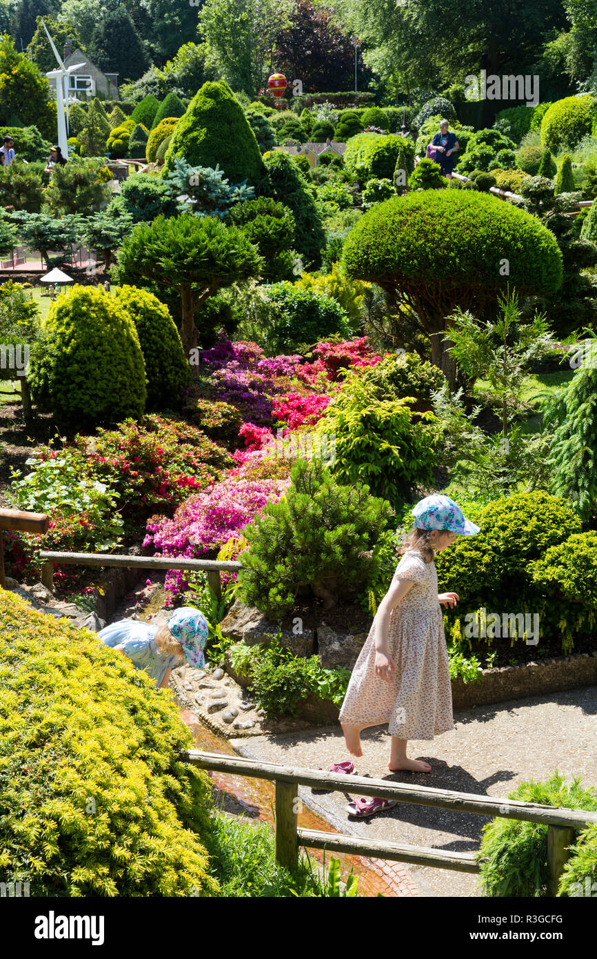 Jeune fille / enfant / enfant / visiteur / touriste/enfants jouant dans le jardin et explorer le village modèle. Godshill, Ventnor, île de Wight (Royaume-Uni) 98 Banque D'Images