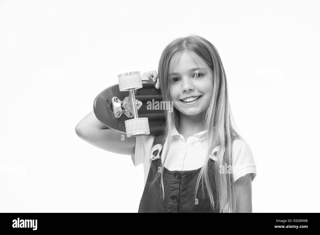 Patineur Enfant souriant de longboard. Né pour être un skater girl. Petite fille sourire avec skate board isolé sur blanc. Skateboard kid avec les cheveux longs. Spo Banque D'Images