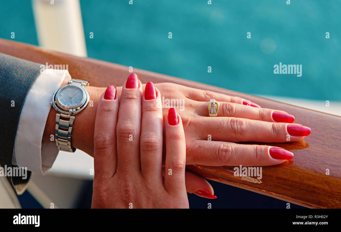 Les mains des femmes et montre-bracelet avec manucure rouge et anneau d'or  avec des diamants sur le doigt près de l'eau, de belles mains avec watch  Photo Stock - Alamy
