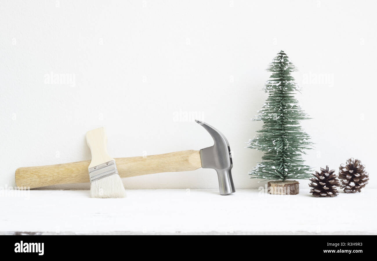 Joyeux Noël et Bonne année avec des outils pratiques concept d'arrière-plan, des marteaux et pinceaux avec arbre de Noël et de cônes de pin décoration sur bois w Banque D'Images