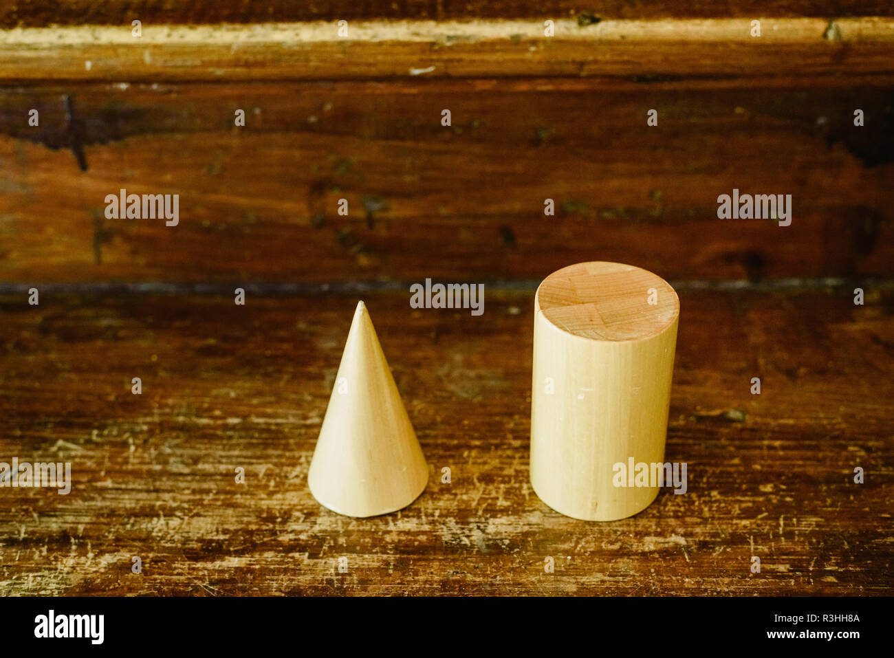 Formes en bois massif pour étudier la géométrie et volumes, des cônes, des triangles, des carrés, des sphères sur un fond de bois chaleureux. Banque D'Images