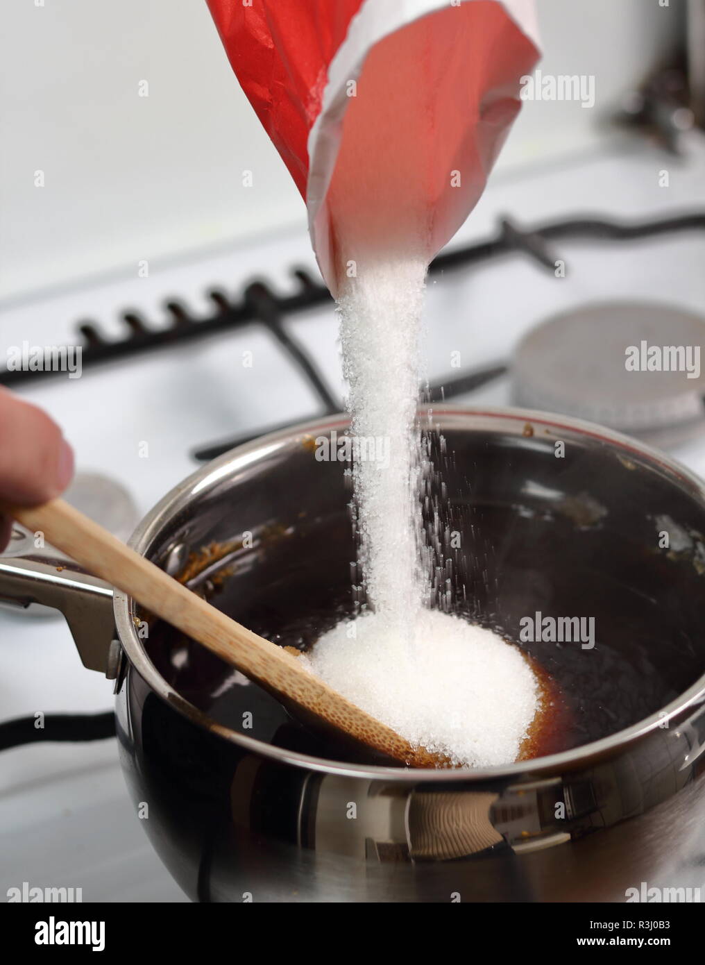 Ajouter le sucre au mlange d'eau et de sucre caramlis. Faire le sirop  d'or srie Photo Stock - Alamy