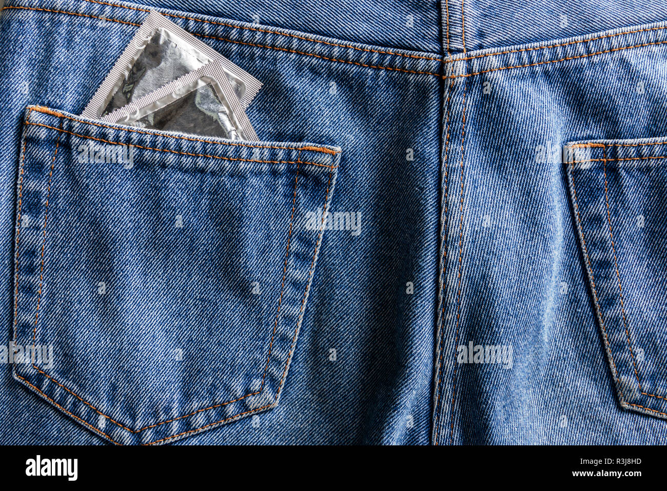 Paire de préservatifs en argent de poche jeans bleu Banque D'Images