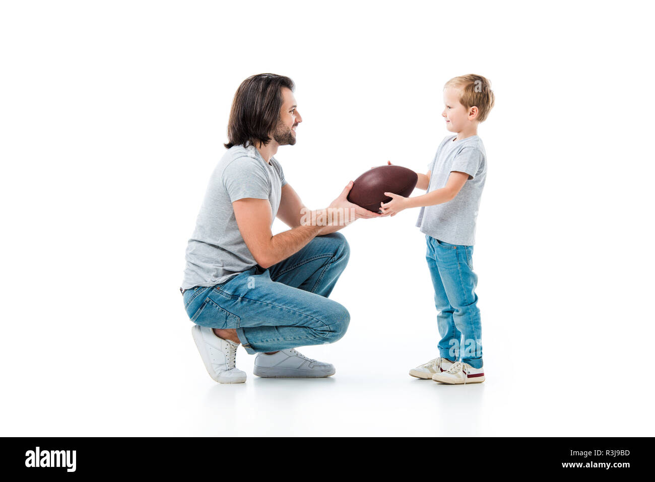 Père aimant donner balle de football américain à son fils isolated on white Banque D'Images