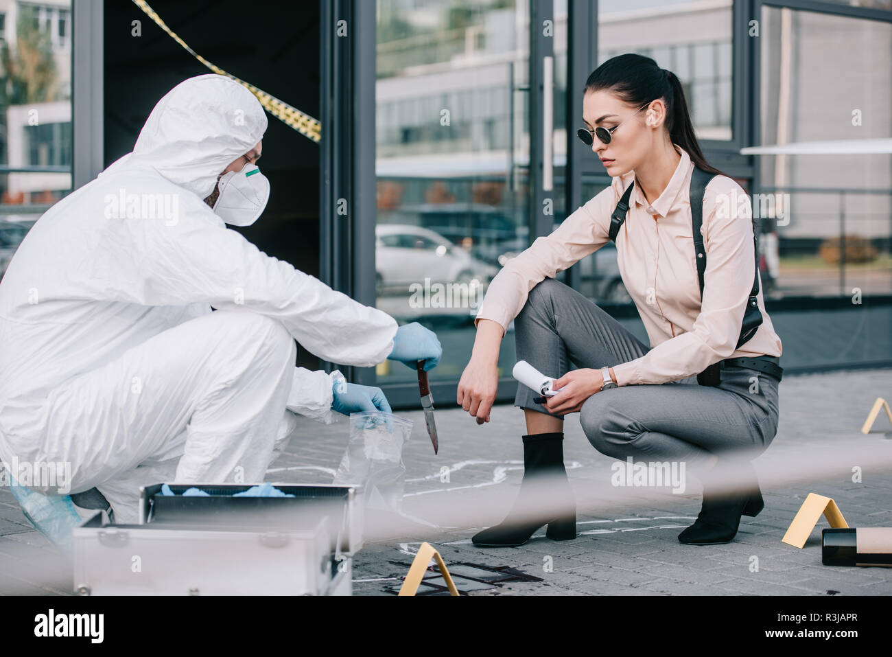 Couteau comme un criminologue montre arme du crime de détective féminin Banque D'Images