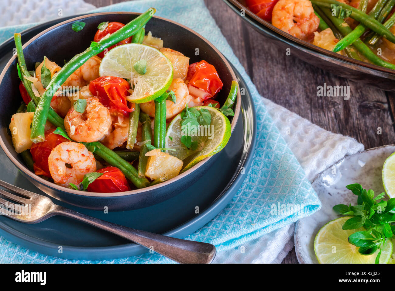 Crevettes thaï à l'ananas et les haricots verts sur table en bois rustique Banque D'Images