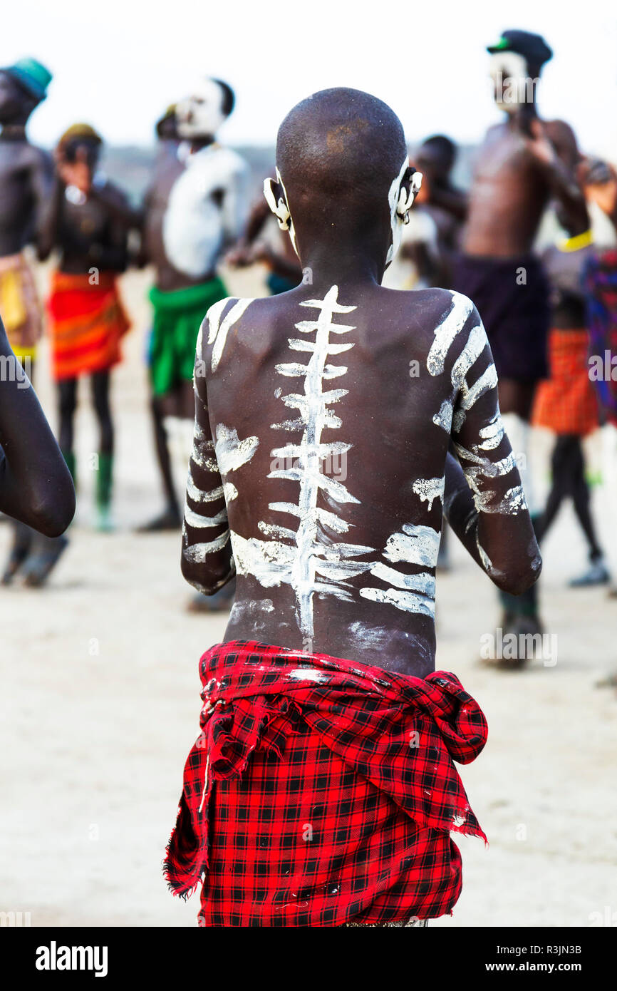 L'Afrique, l'Ethiopie, le sud de la vallée de l'Omo, Tribu Nyangatom. Un jeune garçon est décorée avec des contours du squelette. Banque D'Images