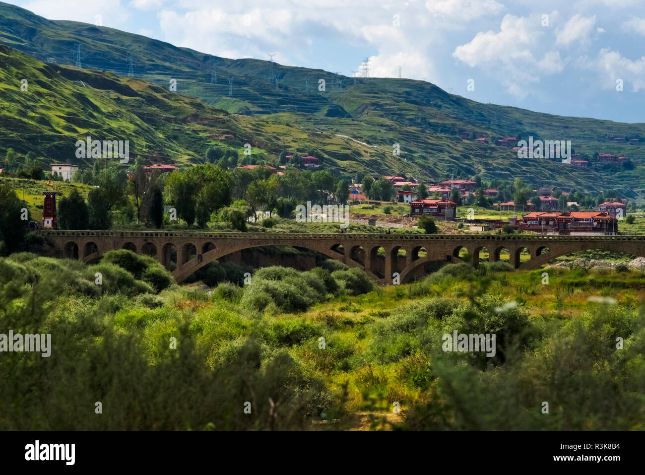 Village et pont sur la rivière dans la montagne, Luhuo, préfecture autonome tibétaine de Garze, l'ouest du Sichuan, Chine Banque D'Images