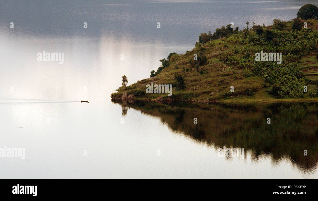Le lac Kivu, le Rwanda, l'Afrique. Un petit bateau s'approche d'une île au milieu du lac Kivu. Banque D'Images
