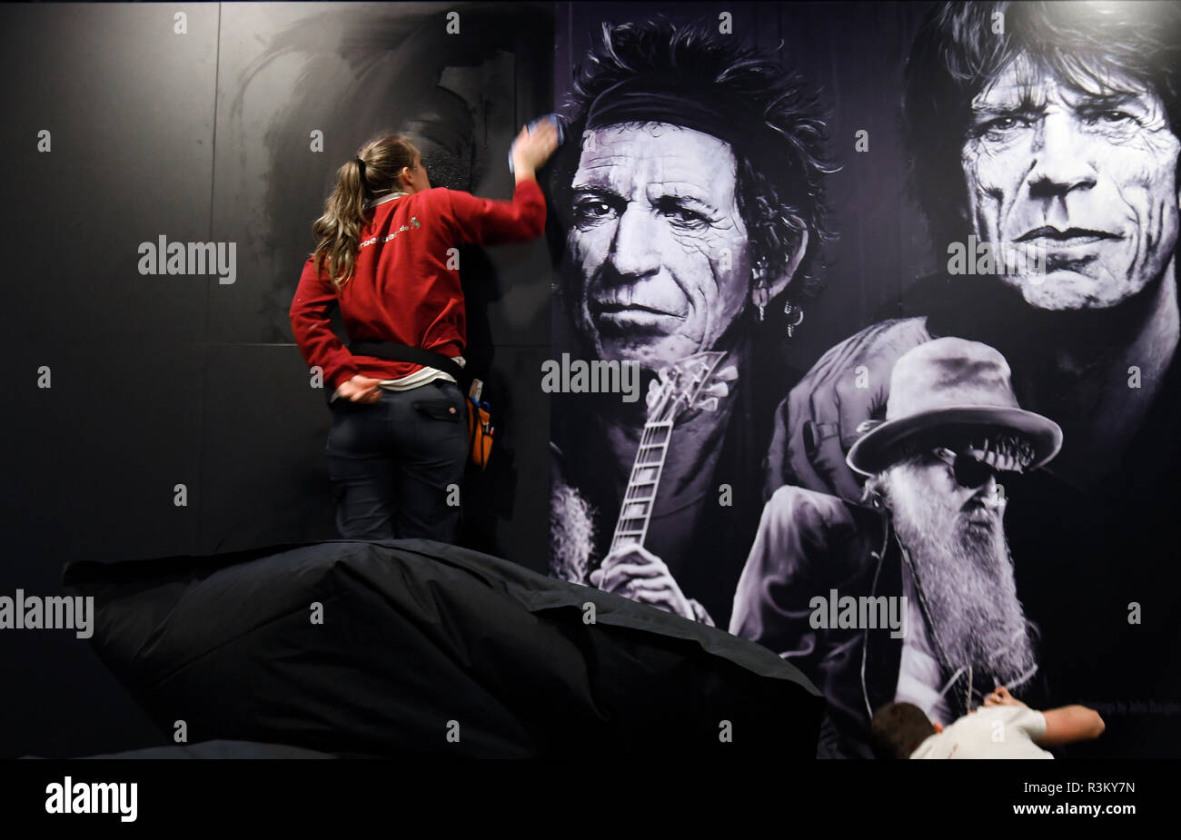 Gronau, Allemagne. 21 Nov, 2018. Dans le "rock'n'popmuseum' un membre du personnel s'enfonce un poster du groupe Rolling Stones avec les membres du groupe Keith Richards et Mick Jagger (r) sur un mur. Europe's premier rock et pop musée dans la région de Münster ouvre ses portes aux visiteurs de nouveau le 25 novembre. Neuf domaines thématiques ont été mis en place, dédié à des aspects tels que la mode comme rébellion. (Dpa : "Rock'n'Pop-Museum Gronau : une année de reconstruction" du 23.11.2018) Crédit : Ina Fassbender/dpa/Alamy Live News Banque D'Images