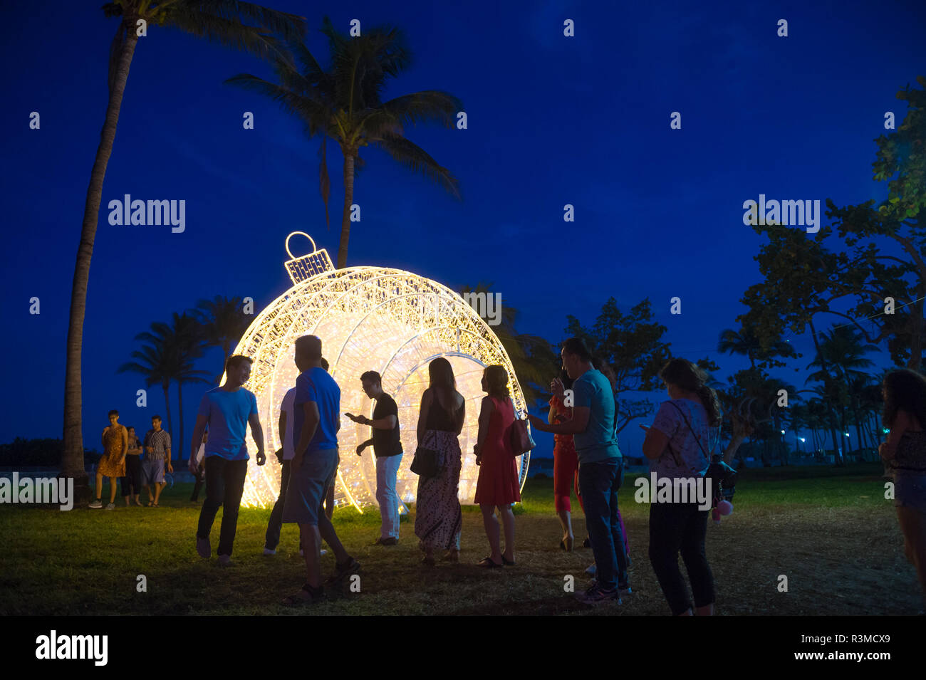 MIAMI - CIRCA DÉCEMBRE 2017 : Les visiteurs se réunissent pour prendre des photos en face d'un gigantesque sapin noël ornement situé dans les palmiers de Lummus Park. Banque D'Images