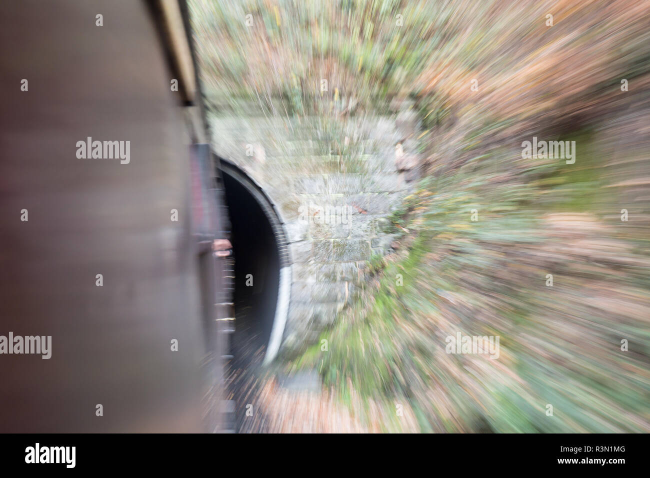 À bord d'un train d'époque en mouvement, vue de la fenêtre avec un flou de mouvement de train rapide à l'approche du tunnel. Concept : vitesse, mouvement, déplacement rapide. Banque D'Images