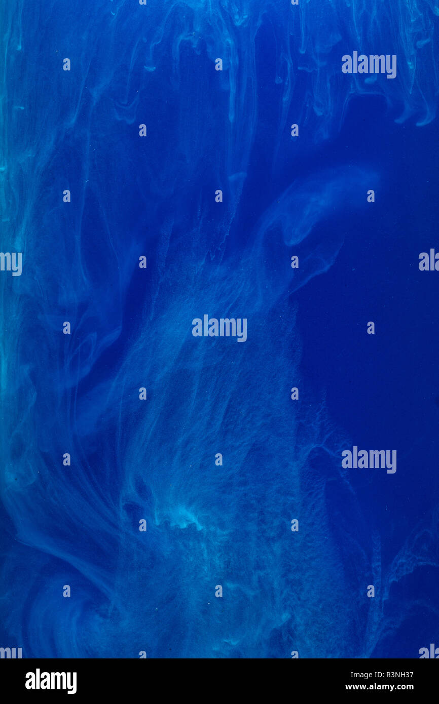 Abstract pattern de tomber dans l'eau goutte d'encre bleu encre cyan - dissous dans l'eau sur bleu Banque D'Images
