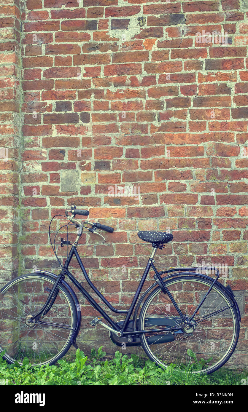 Bycycle garé contre un vieux mur de brique Banque D'Images