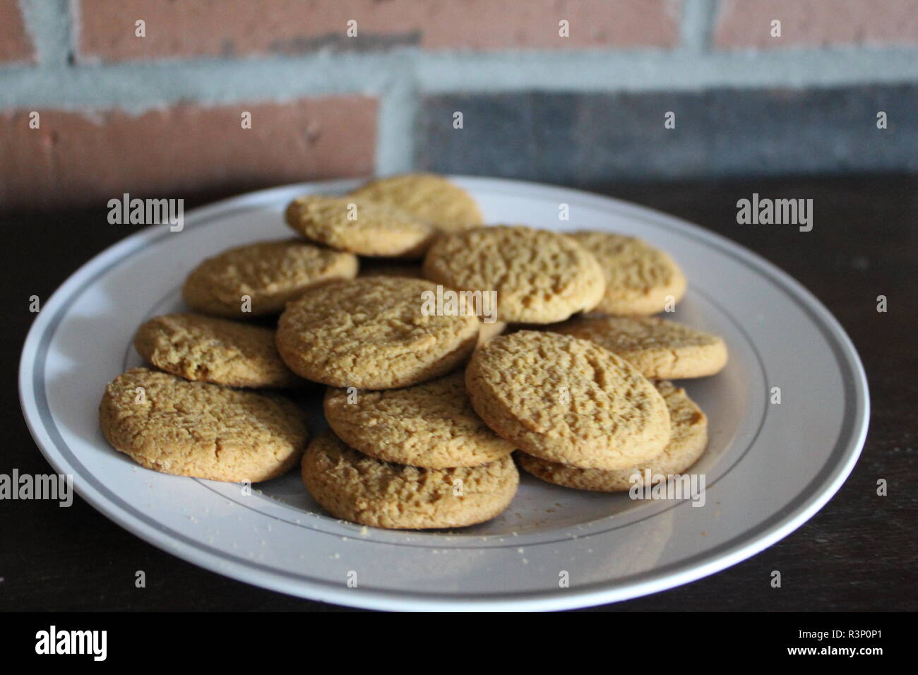 Les cookies sur une plaque blanche avec fond brique Banque D'Images