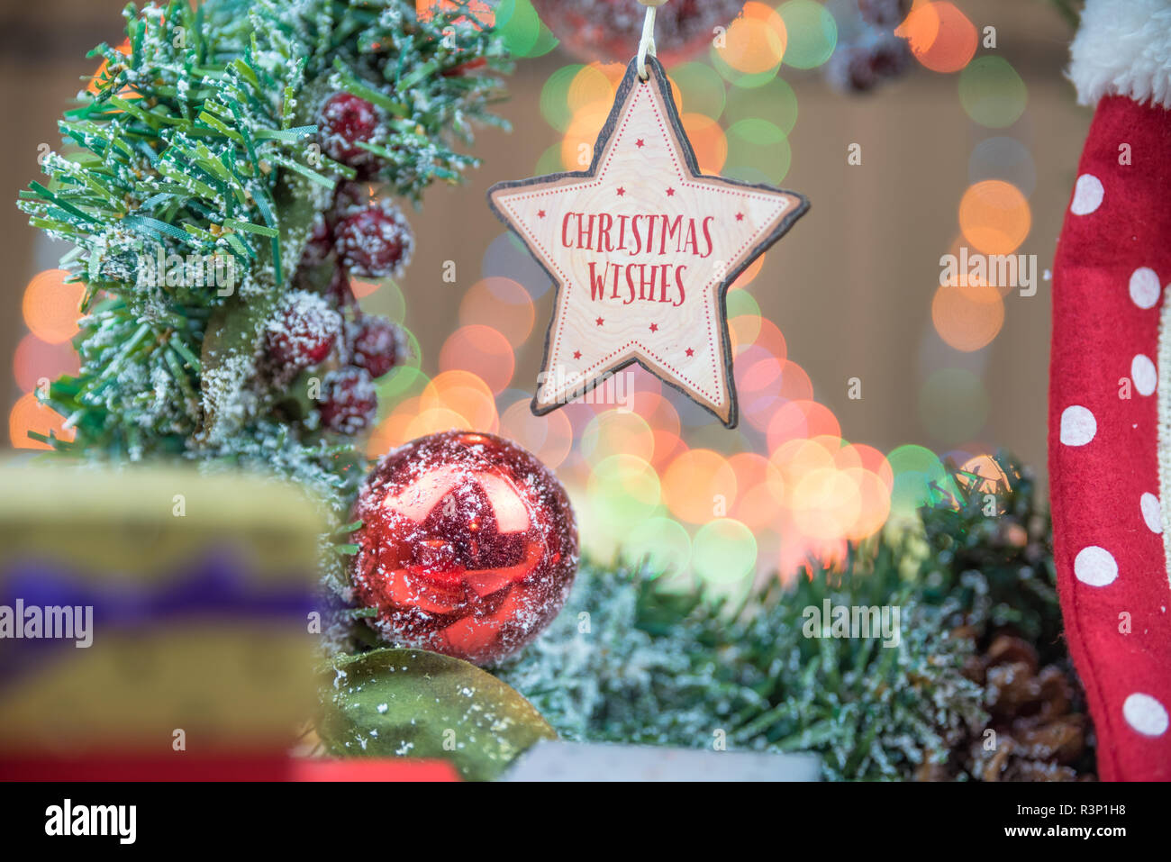 Cadeaux de Noël ou présenter des boîtes. Lumières colorées, des globes et des décorations en arrière-plan, sur la surface en bois rustique. Décoration en bois en forme de Star w Banque D'Images