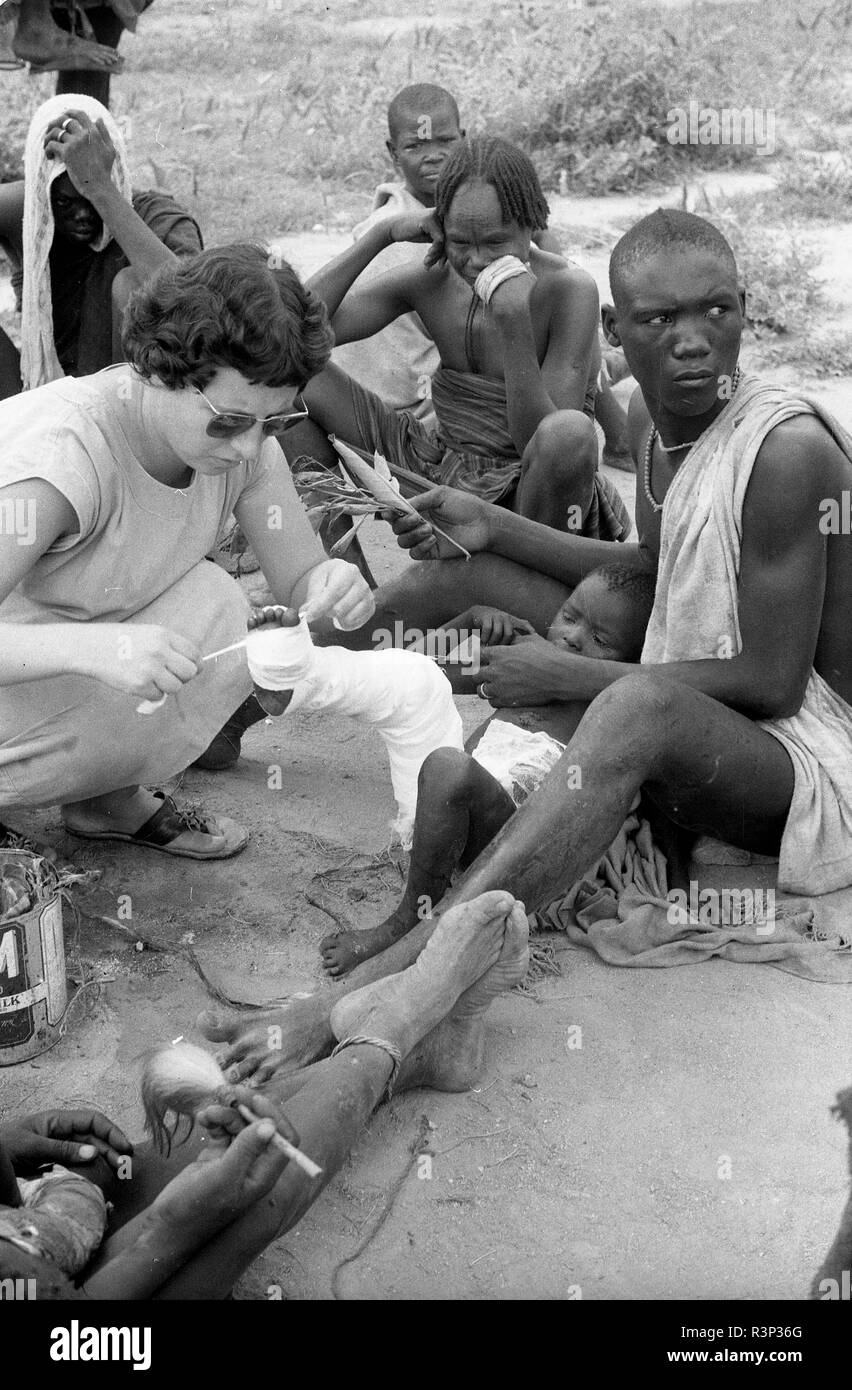 Cameroun 1950 infirmière femme européenne traiter l'enfant blessé Banque D'Images