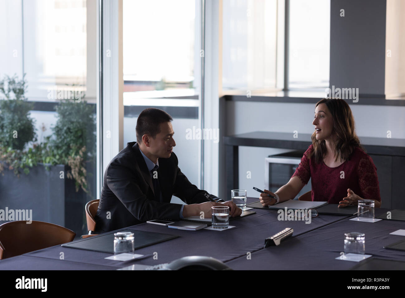 Les gens d'affaires de parler les uns avec les autres dans la salle de conférence Banque D'Images