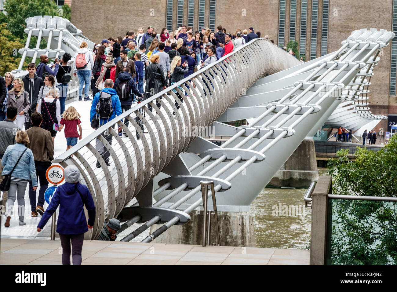 Londres Angleterre,Royaume-Uni,Millennium Bridge,acier suspension,passerelle,piéton traversant la rivière Thames,surpeuplé,multi ethnique multiethnique,homme hommes,femme f Banque D'Images