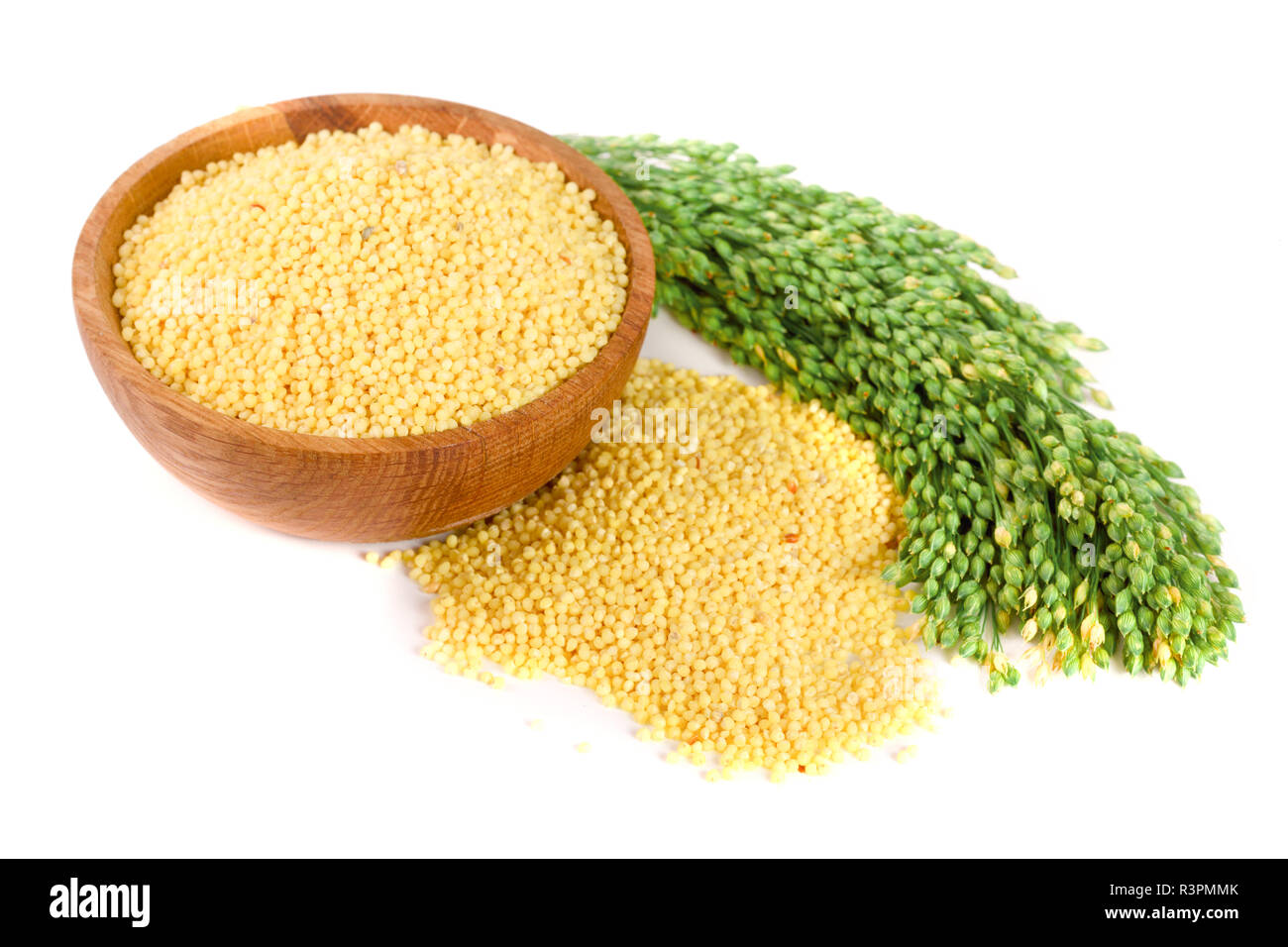 Millet dans bol en bois avec des épillets vert isolé sur fond blanc Banque D'Images