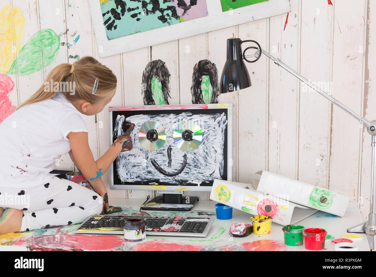 Girl painting des oreilles de lapin sur PC in office Banque D'Images