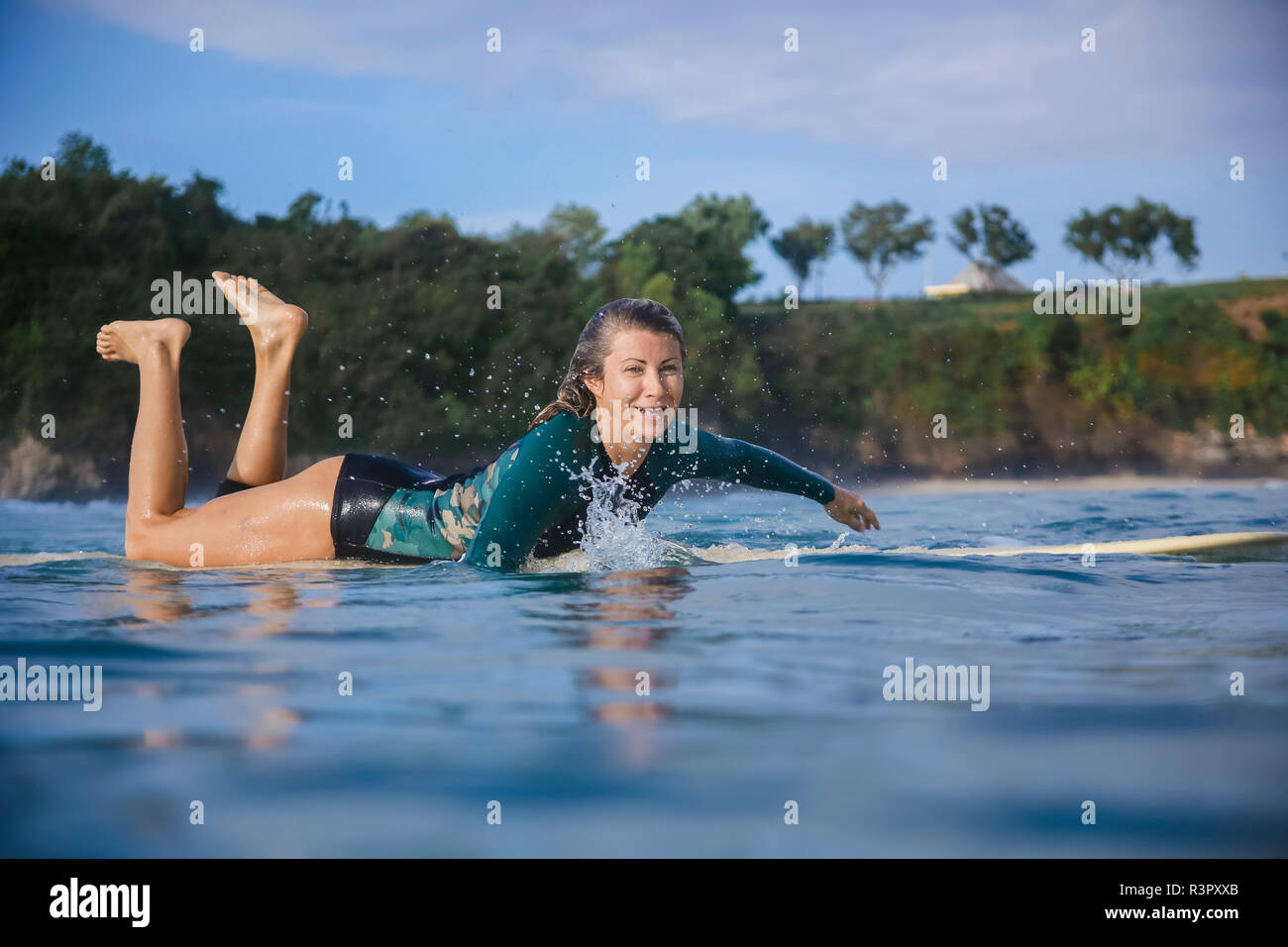 L'INDONÉSIE, Bali, plage de Balangan, femme surfer allongé sur une planche de surf Banque D'Images