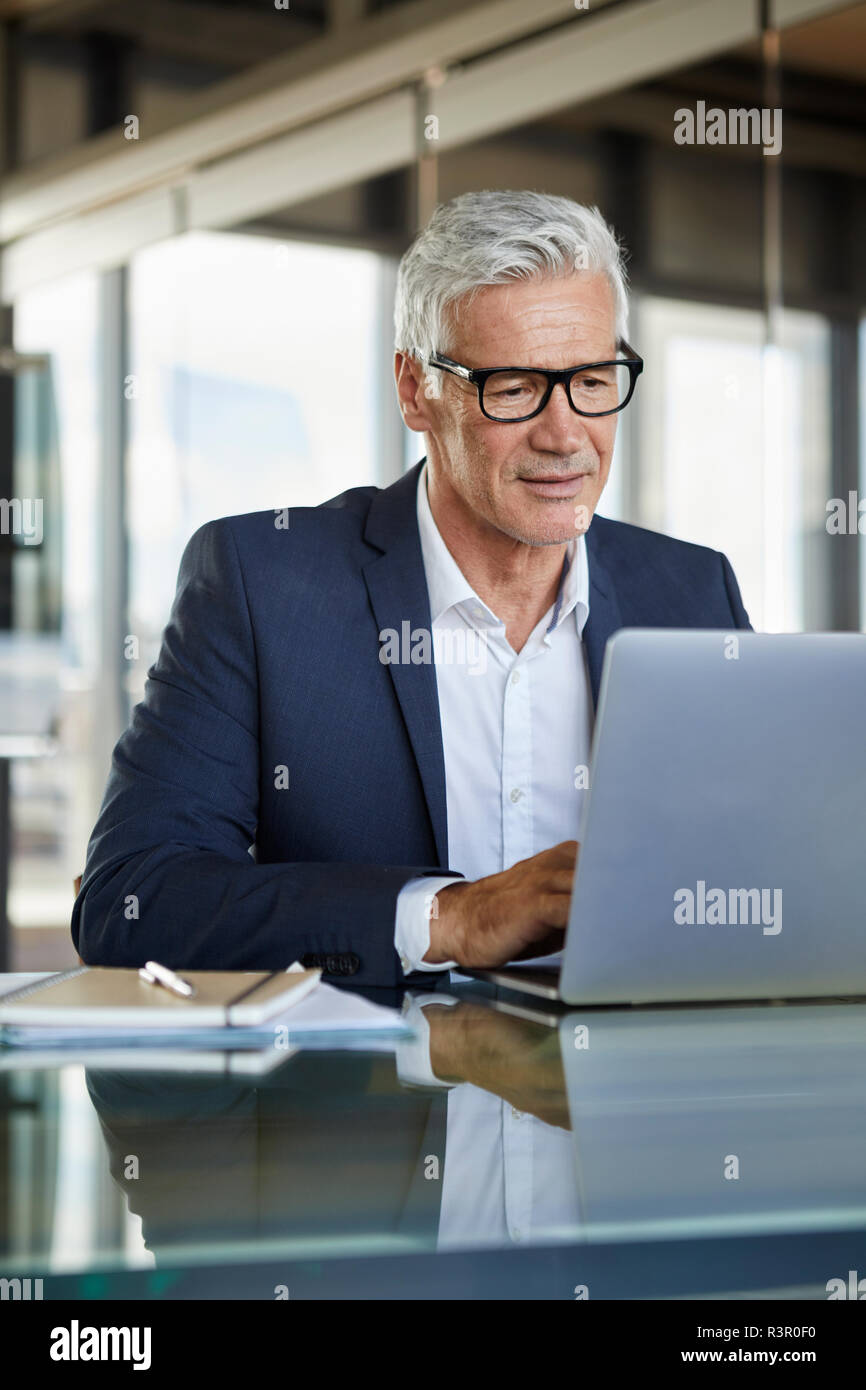 Businessman working in office, using laptop Banque D'Images