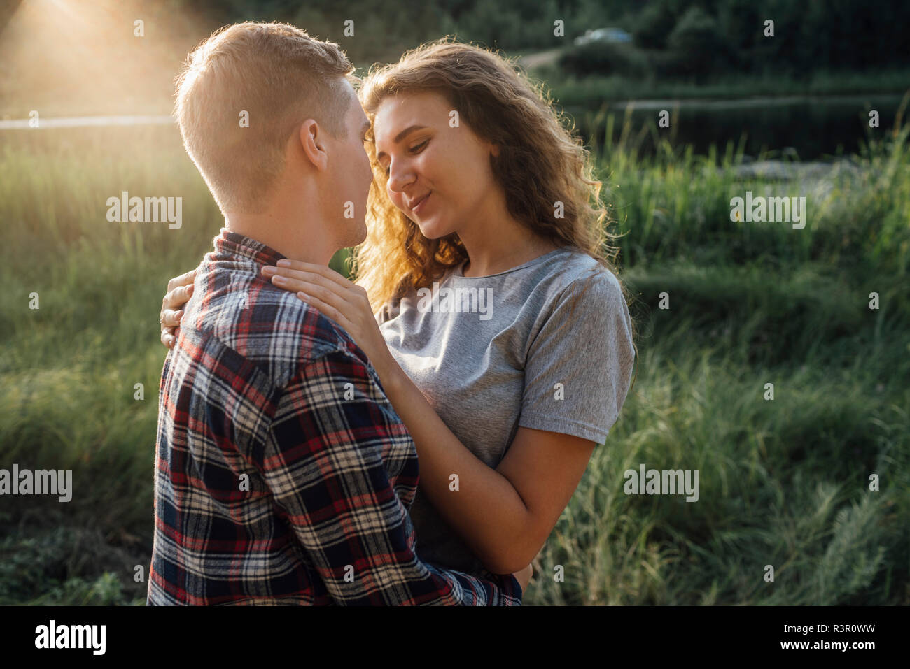 Couple romantique passer du temps dans la nature, les baisers au coucher du soleil Banque D'Images