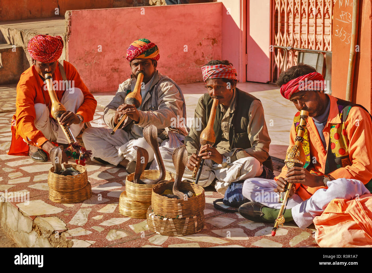 RAJASTHAN JAIPUR EN INDE QUATRE CHARMEURS DE COBRAS ET DANS DES PANIERS Banque D'Images