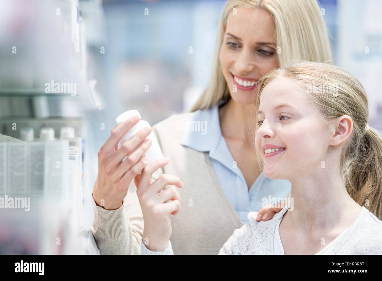 Woman and girl reading label en pharmacie. Banque D'Images