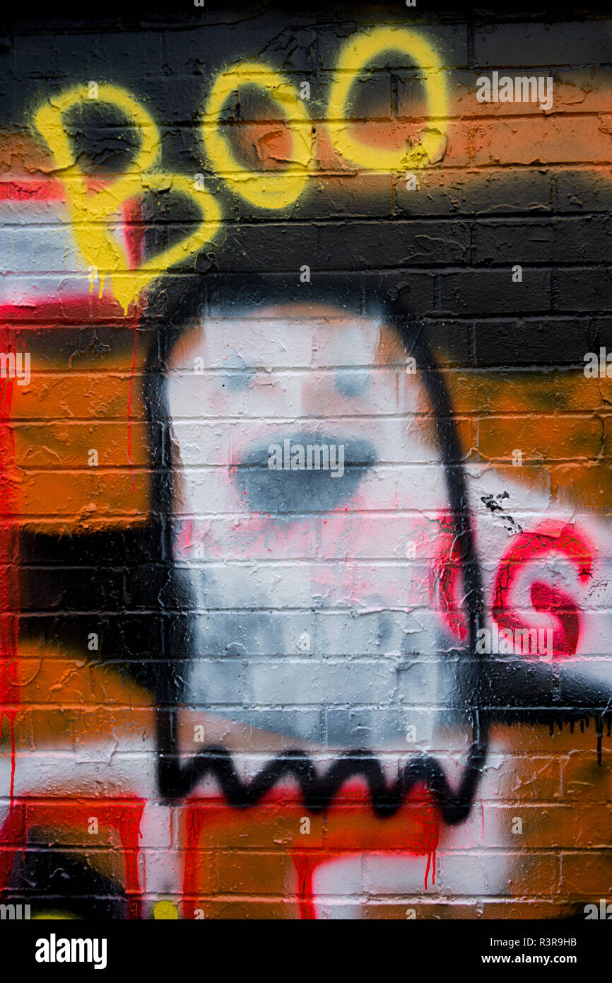 Un fantôme et le mot 'Boo' peint à la bombe sur le côté d'un mur de brique - graffiti Banque D'Images