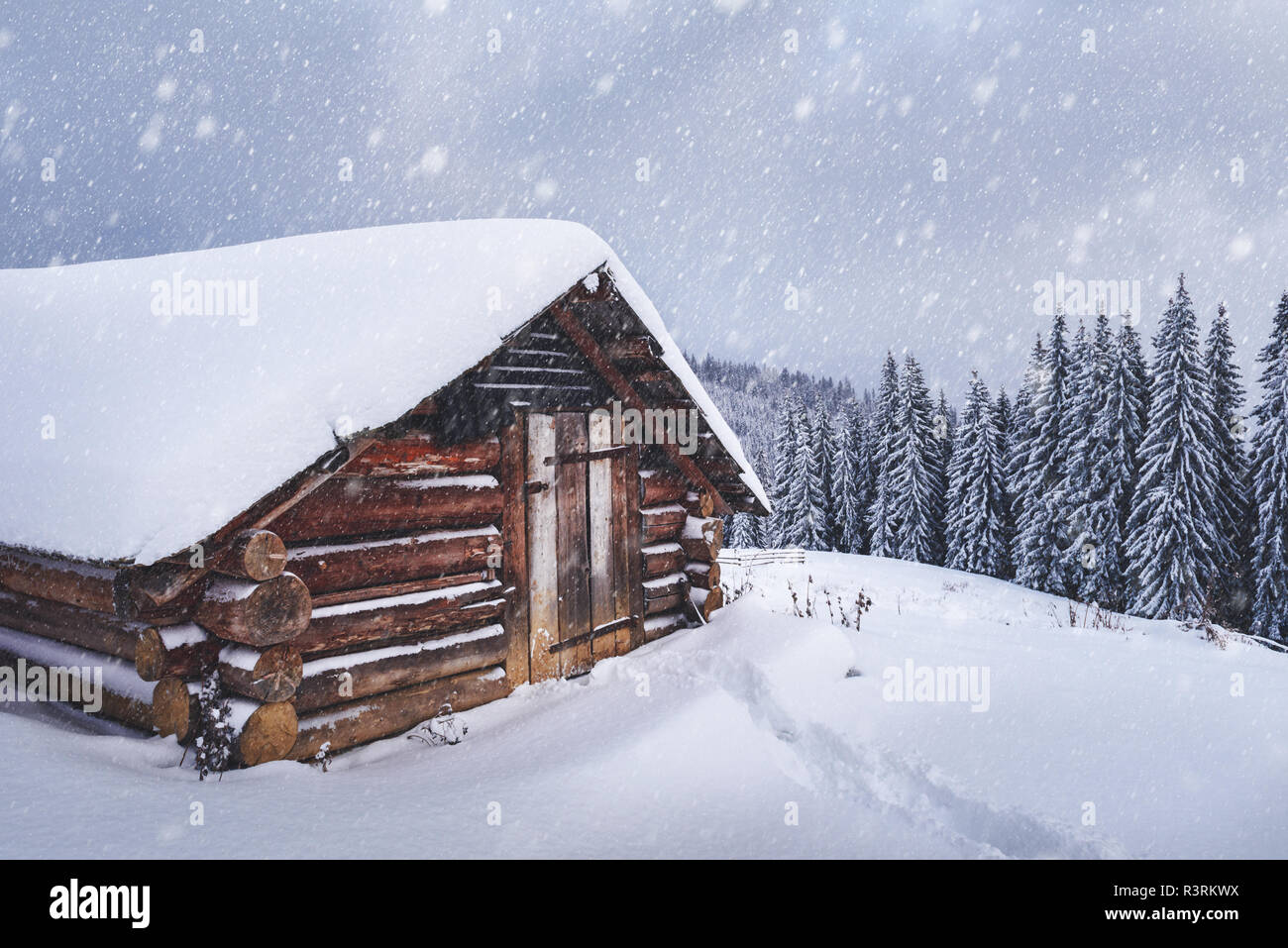 Paysage d'hiver fantastique avec maison en bois dans les montagnes enneigées. Concept de vacances de Noël. La montagne des Carpates, l'Ukraine, l'Europe Banque D'Images