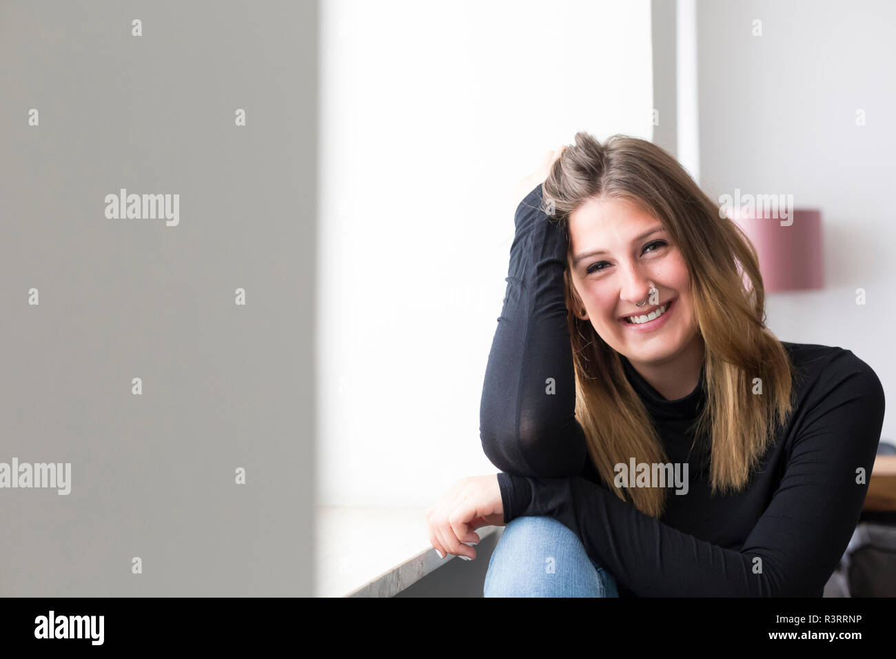 Portrait of happy young woman avec nez piercing à la maison Banque D'Images