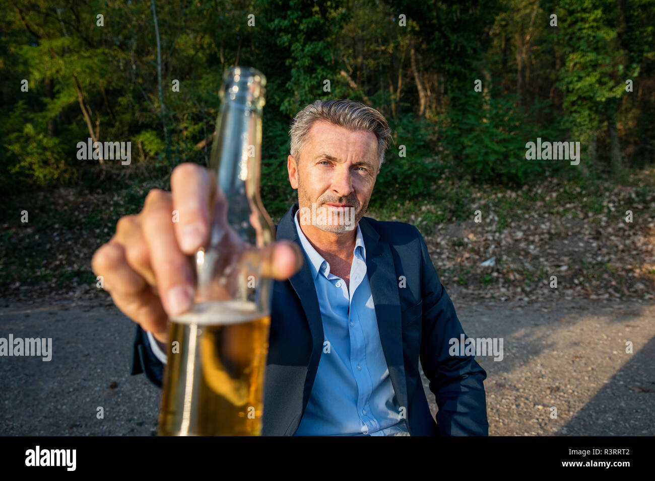 Portrait of mature businessman toasting with beer dans la nature Banque D'Images