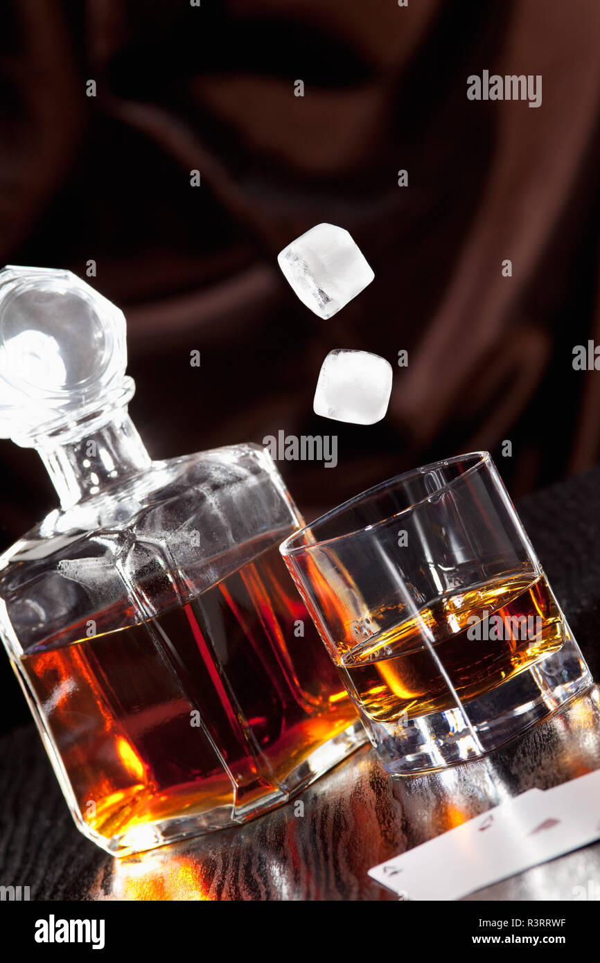 Des cubes de glace tomber dans un verre à whisky Banque D'Images
