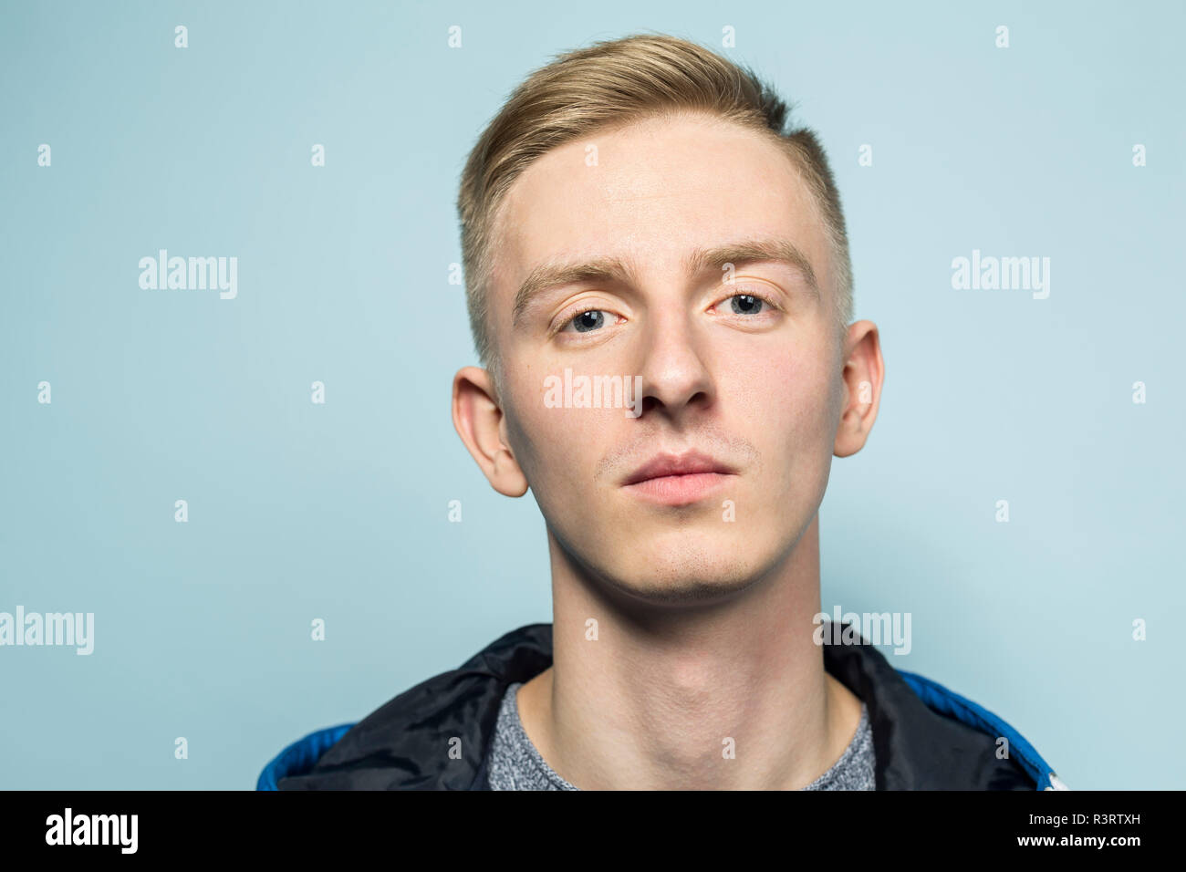 Portrait de jeune homme seious devant fond bleu Banque D'Images