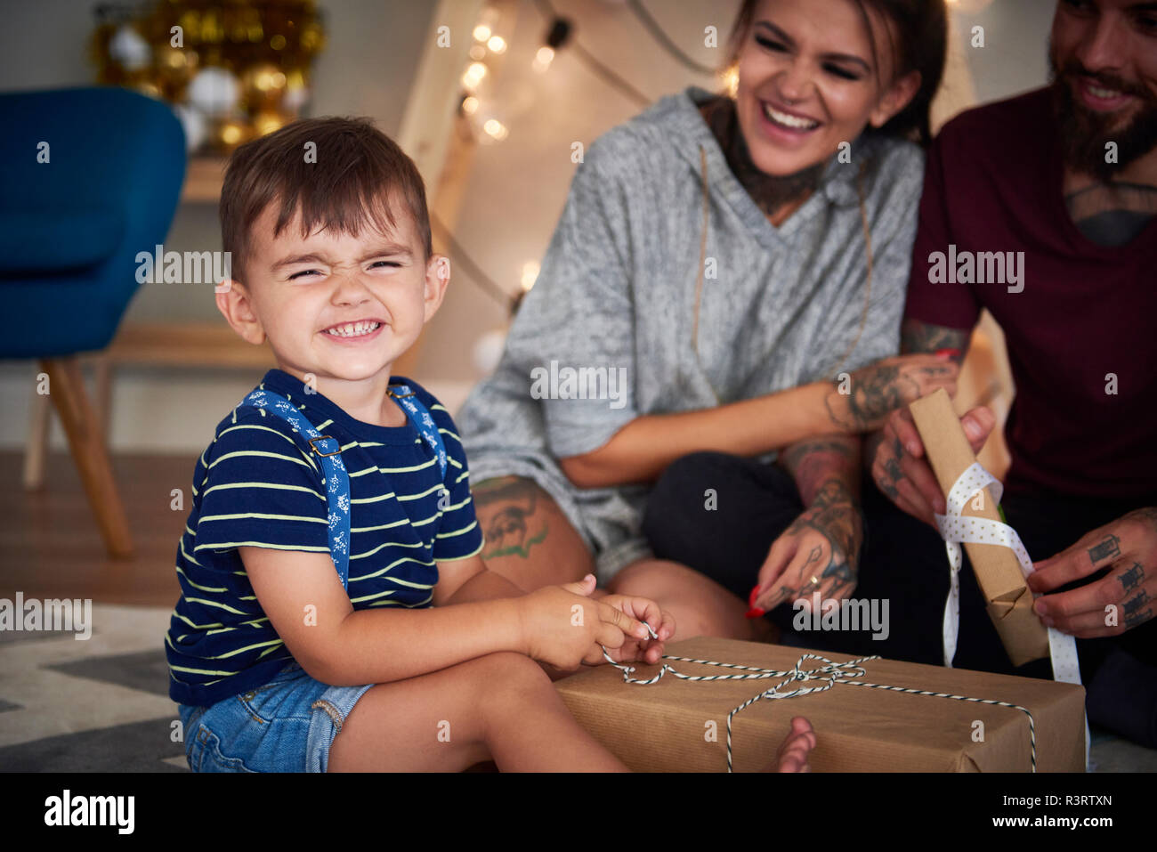 Portrait of boy opening Christmas present at home Banque D'Images