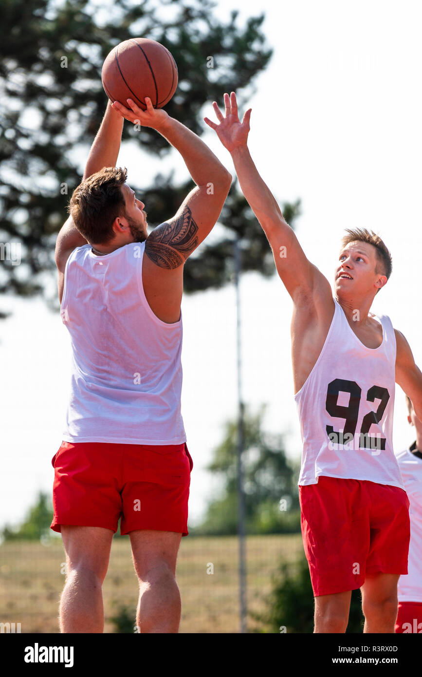 Deux jeunes hommes jouant au basket-ball Banque D'Images