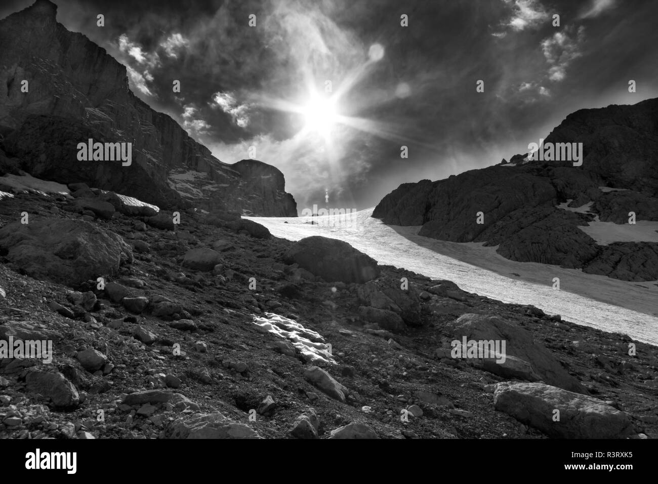 Le col de montagne de neige et ciel avec soleil et rayons de soleil. La Turquie, Monts Taurus centrale, Aladaglar (Anti-Taurus). Paysage aux tons noir et blanc. Banque D'Images