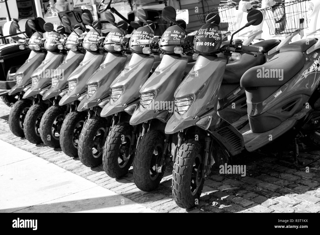 Key West, Floride - 09 janvier, 2016 : rouge des scooters ou des motos à vendre ou louer dans la rangée permanent avec les roues et les lumières journée ensoleillée à l'extérieur, l'embauche de Tr Banque D'Images