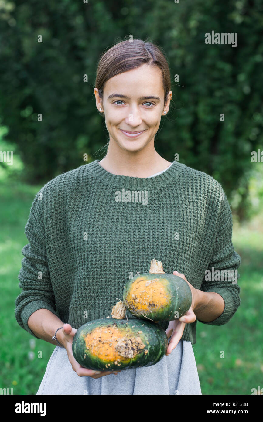 Porrtait de jeune femme avec deux citrouilles dans le jardin Banque D'Images